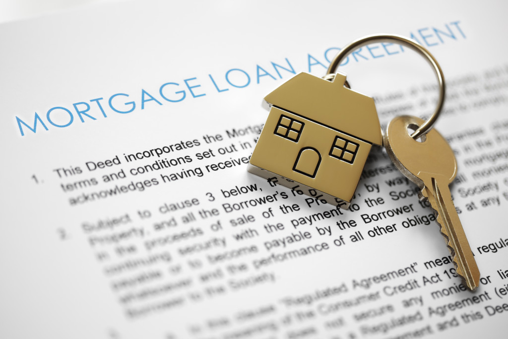 Mortgage loan documents with house keyring and key