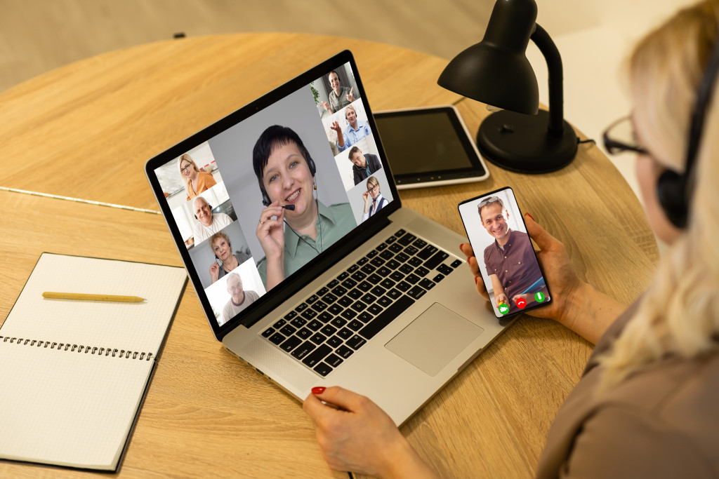 a woman talking to people on her phone and laptop