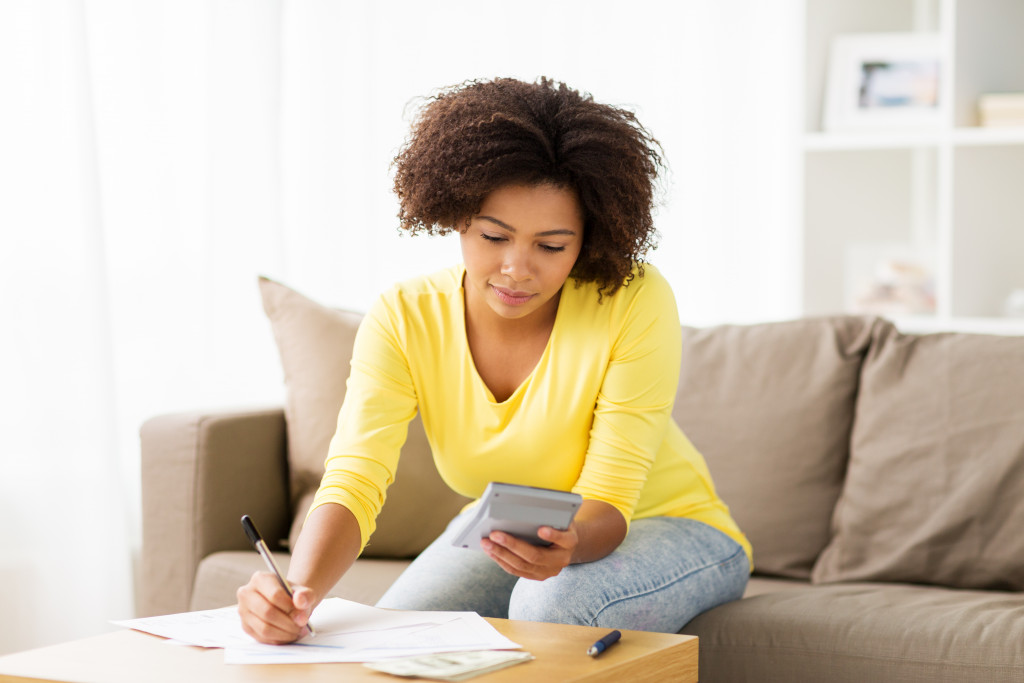 woman checking her finances using calculator