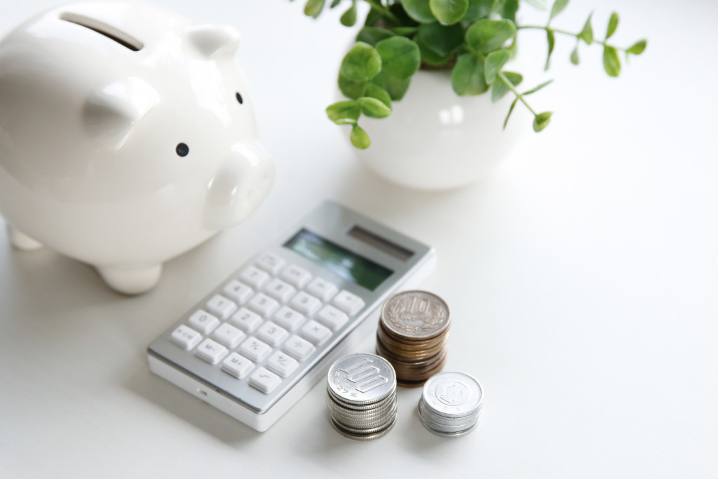 calculator, coins, and a piggy bank