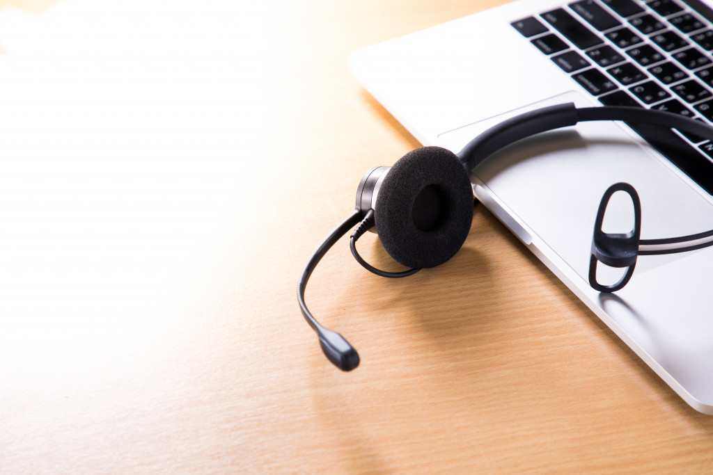 black headset placed on top of macbook laptop