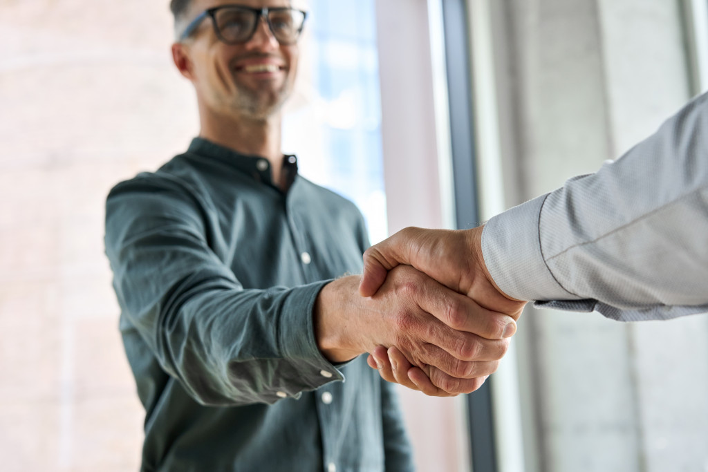 businessmen shaking hands after closing a deal or partnership