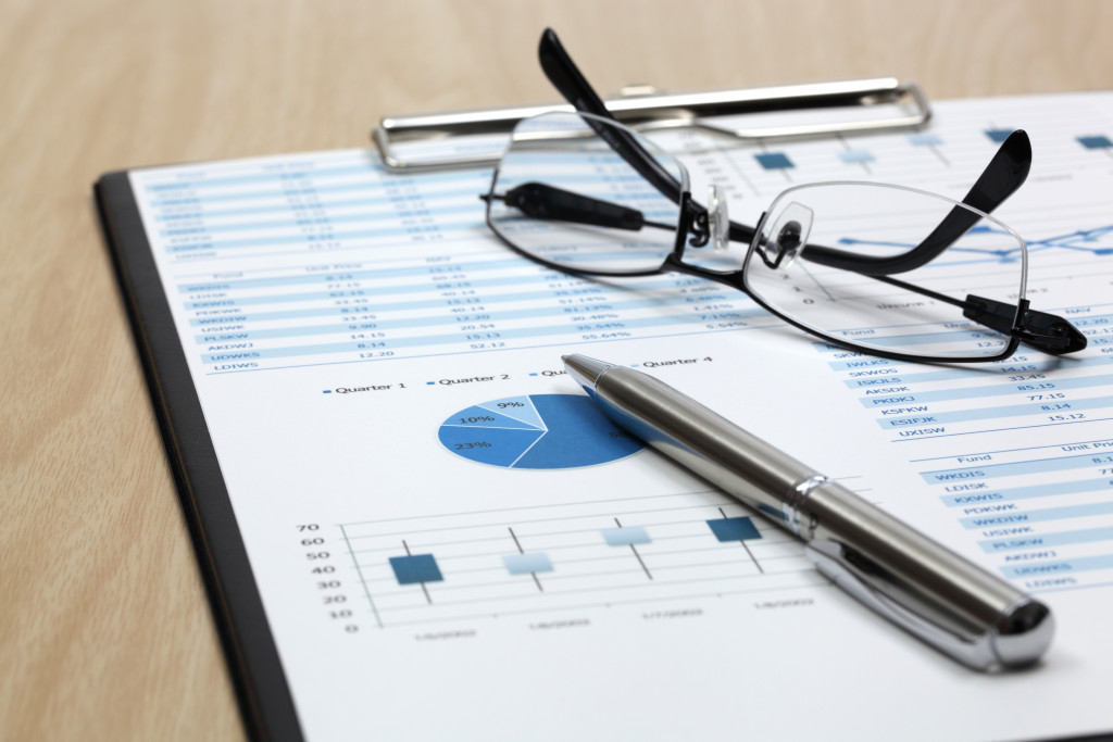 clipboard with document of charts and eyeglasses on top