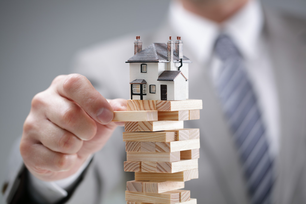 businessman playing jenga to reach the goal of investment property