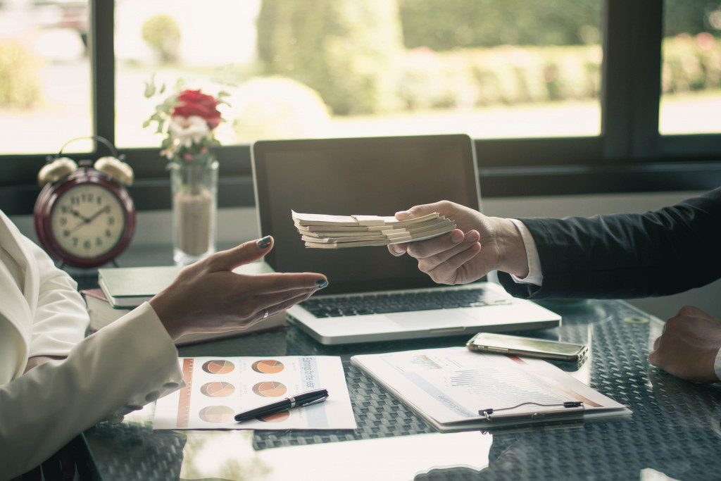 a bank tansaction man handing money to banker