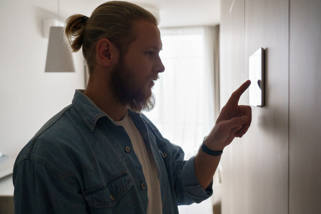 A man adjusting a thermostat