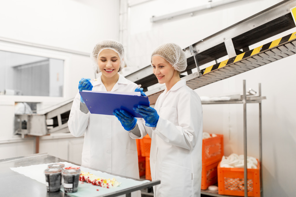 two women checking food using a computer 