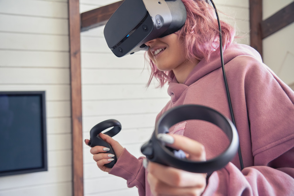 A girl using VR goggles and hand controllers