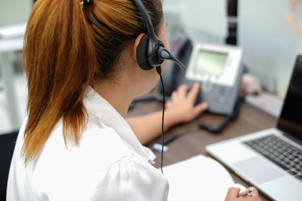 Customer service representative answering a phone at work.